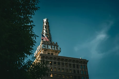 The iconic Walker Center building in Salt Lake City captured with an American flag flying against a blue sky