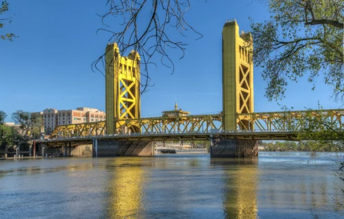 Golden Tower Bridge spans the Sacramento River on a clear, sunny day