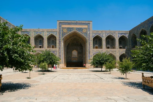 Stunning facade of an Islamic architectural landmark with intricate tilework under a clear blue sky