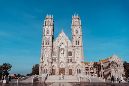 Stunning view of a Gothic-style church under a clear blue sky in Vietnam, showcasing intricate architectural details