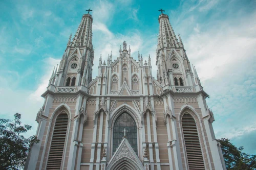 Gothic Revival style cathedral with intricate facades set against a bright blue sky, capturing architectural elegance