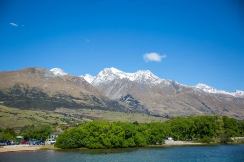 Captivating view of snow-capped mountains and lush greenery under a bright blue sky